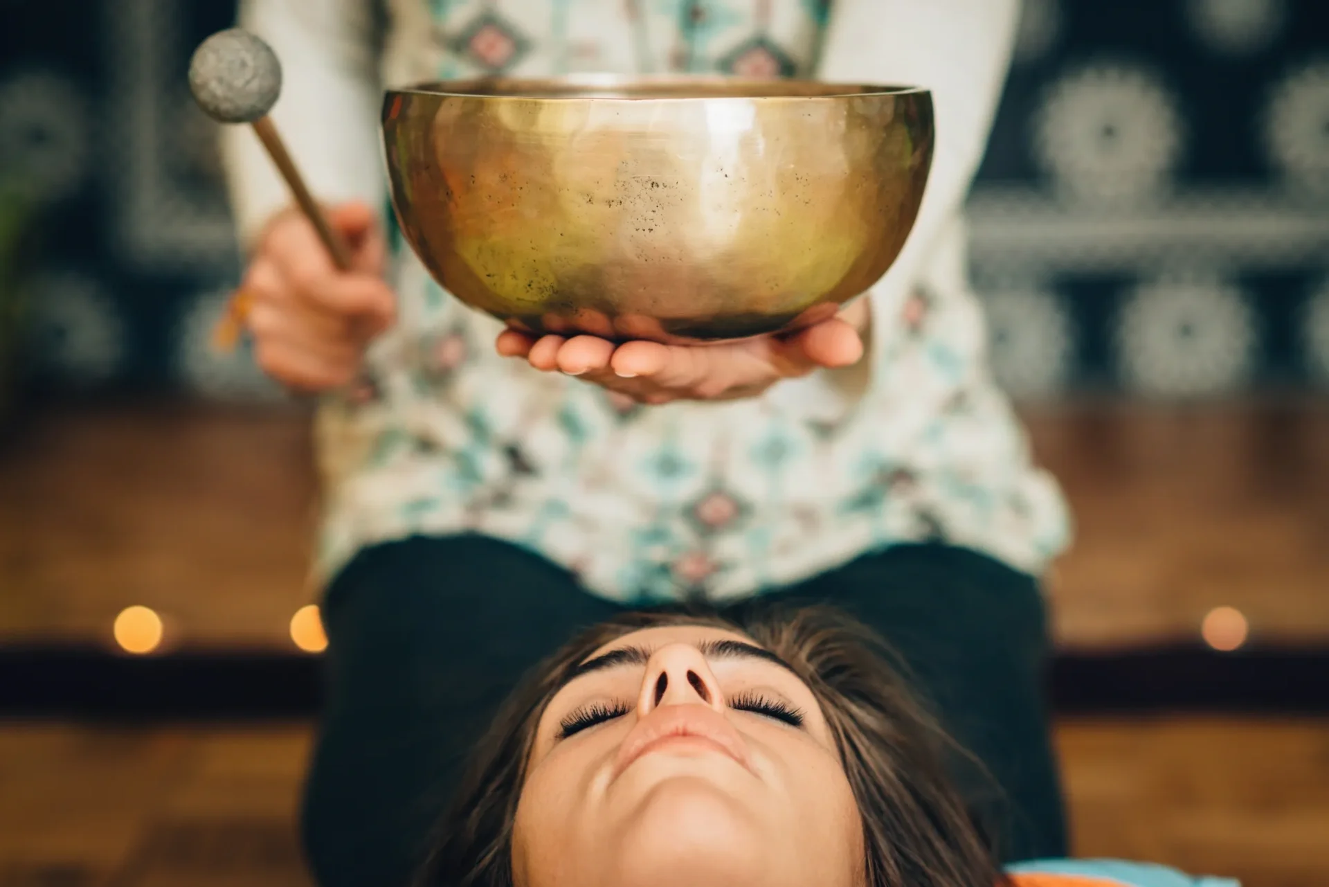 A woman is holding a singing bowl in her hands.