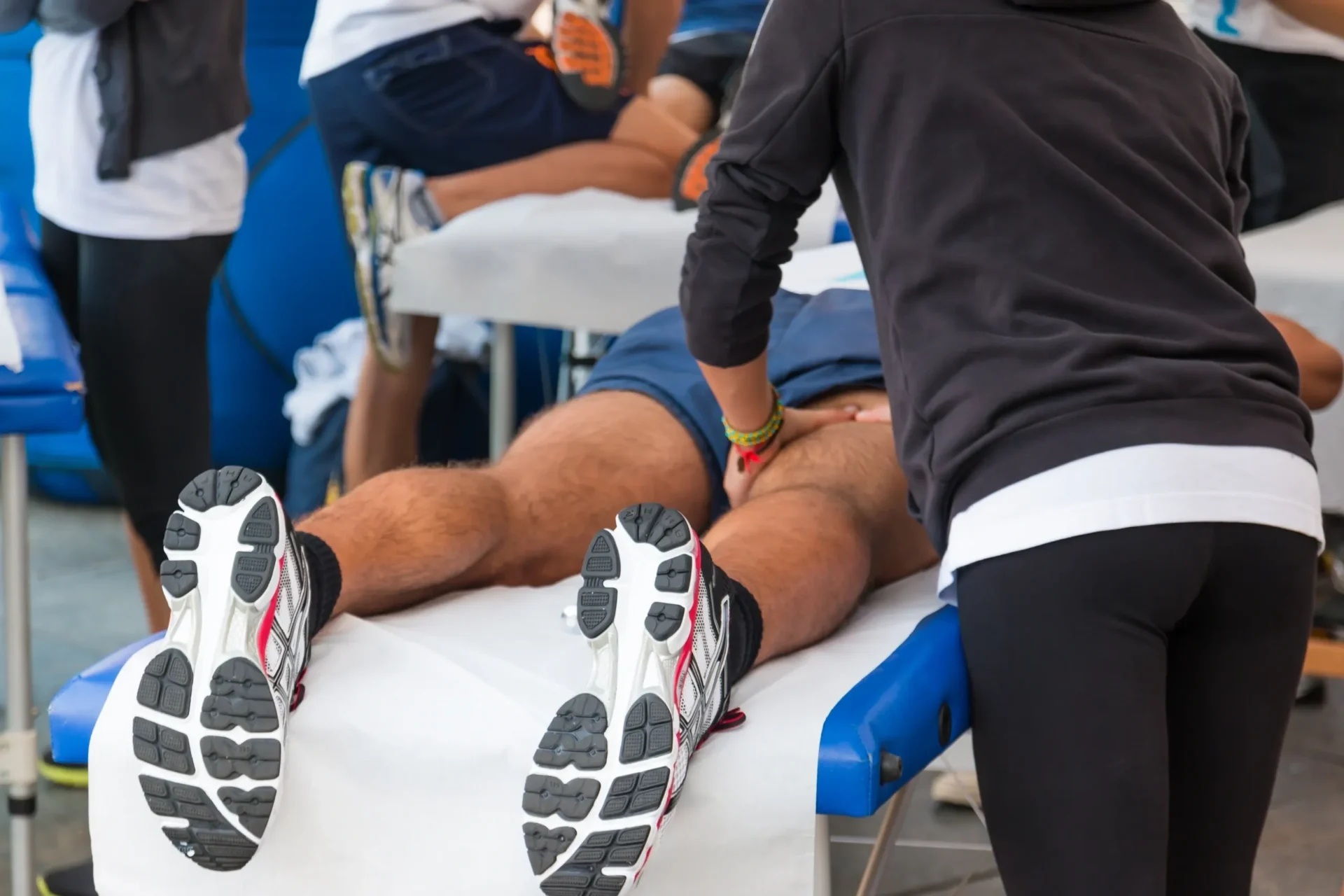 A man is getting his legs waxed by an athlete.