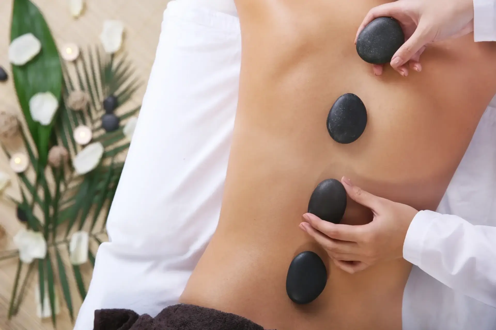 A person getting their back covered with hot stones.